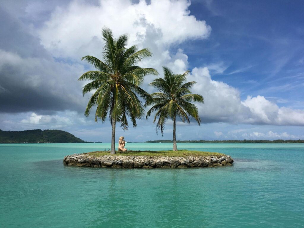 Woman relaxing on private island with palm trees in Bora Bora