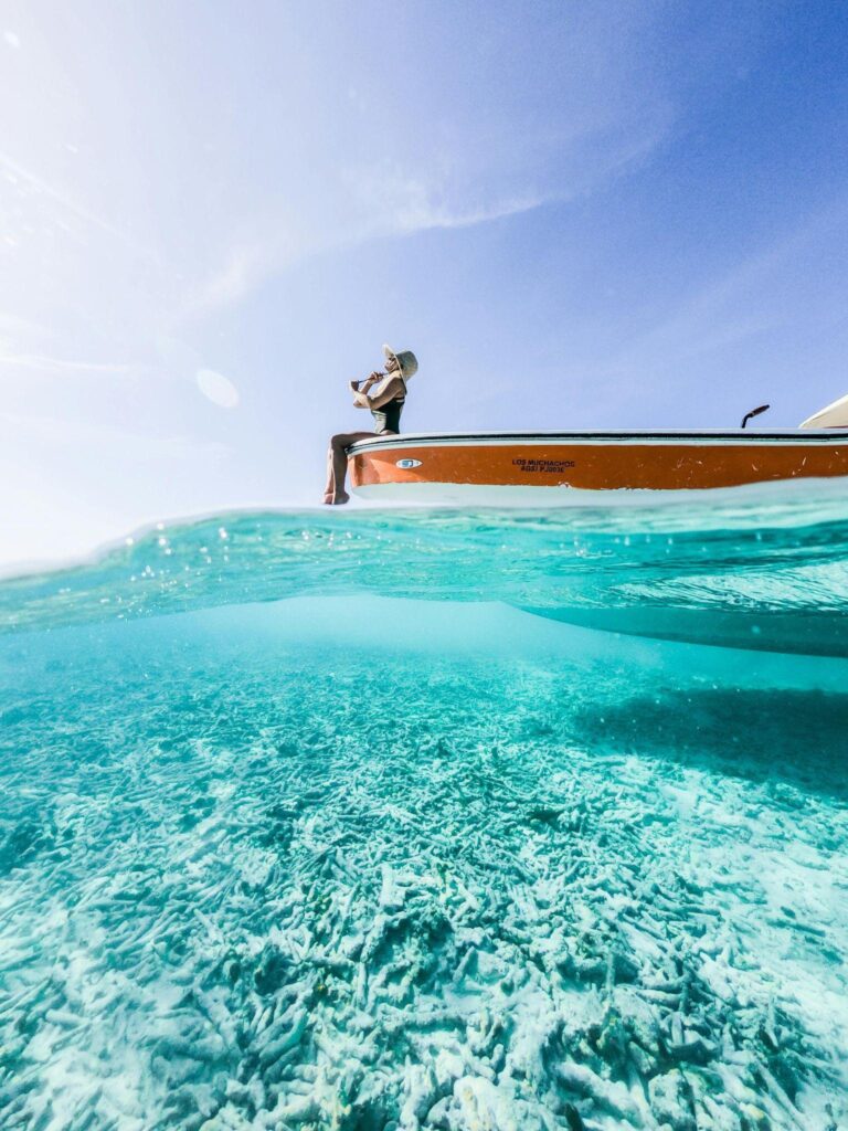 Woman sitting on boat over crystal clear turquoise water