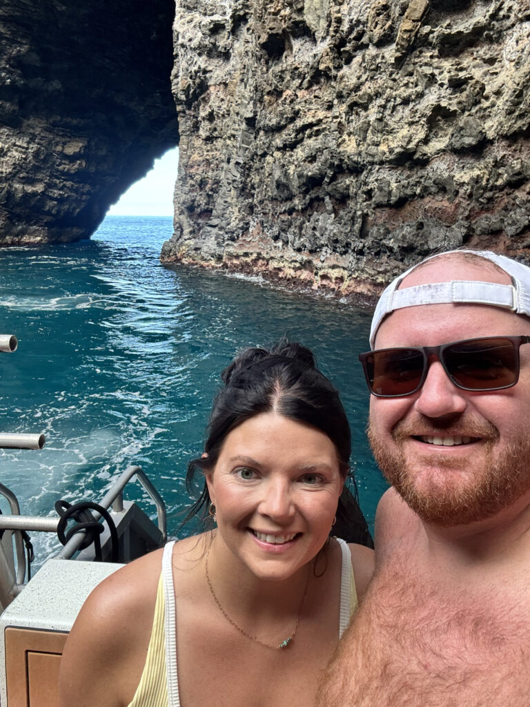 Couple on catamaran tour inside sea cave on Na Pali Coast Kauai