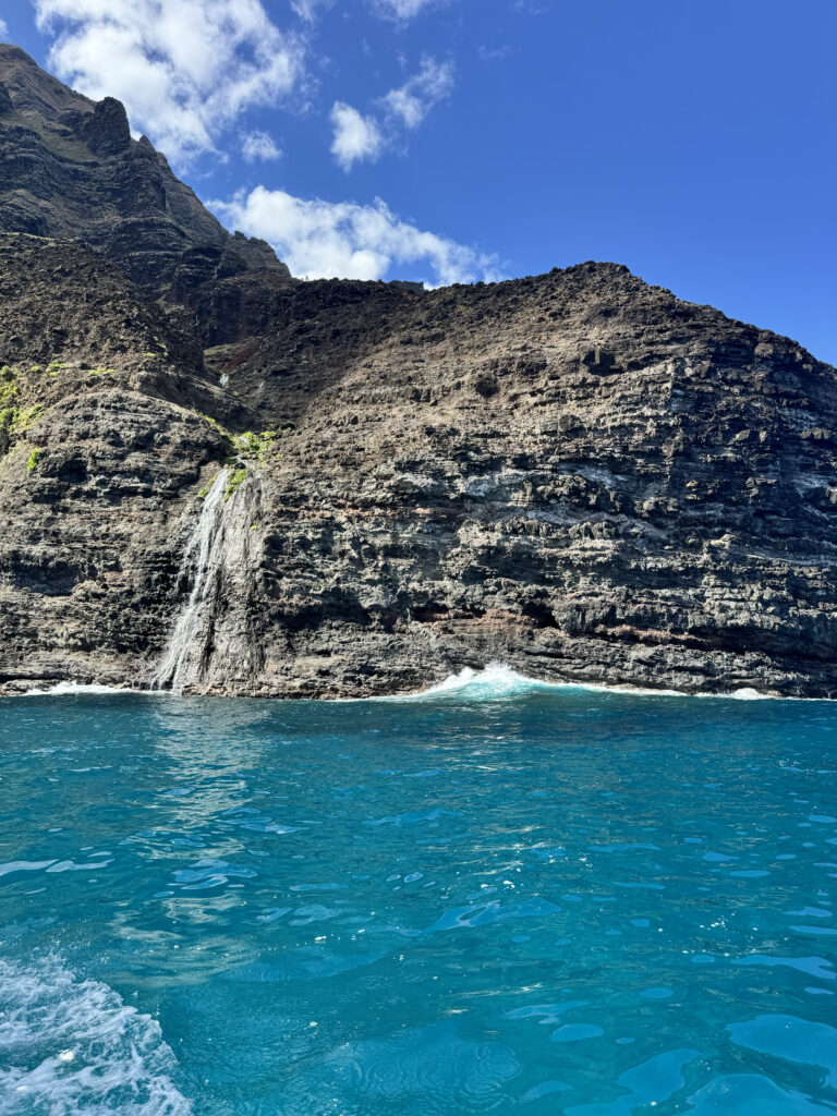 Na Pali Coast cliffs with waterfall cascading into the ocean