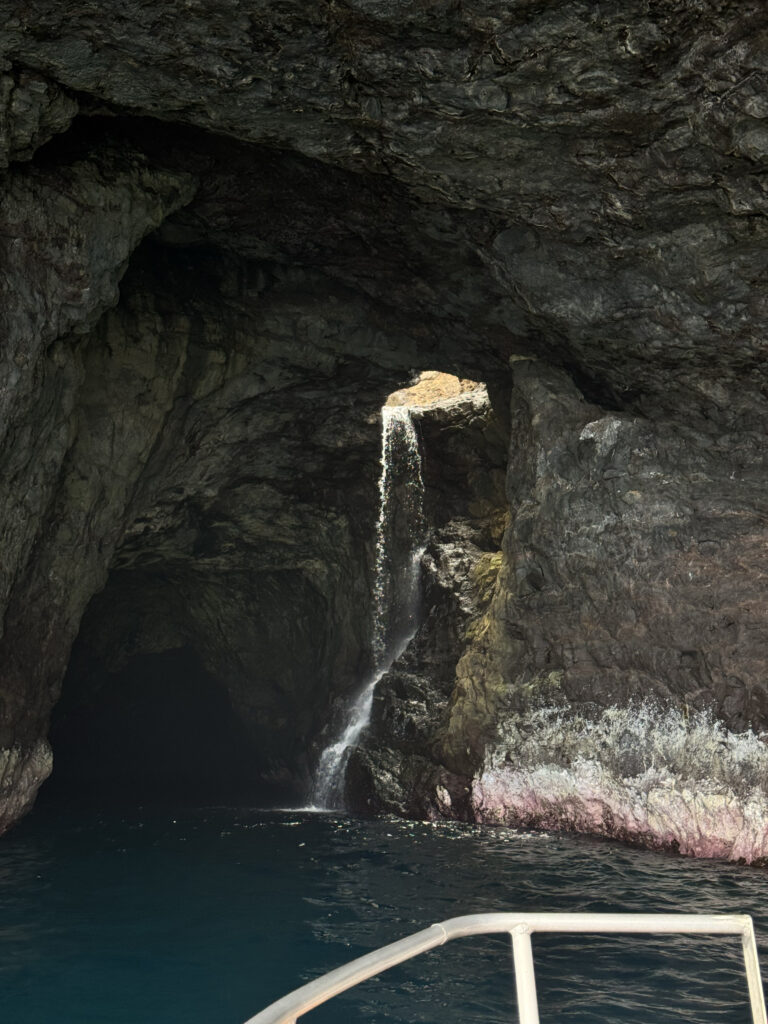 Waterfall inside sea cave on Na Pali Coast boat tour