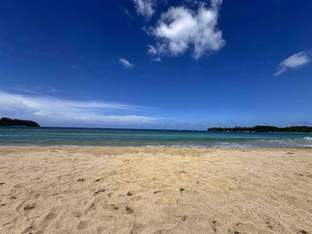 Sandy beach and blue ocean on Kauai's coastline