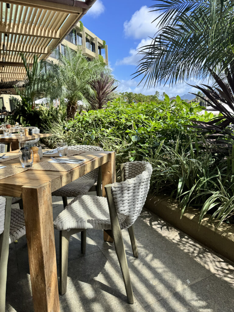 Outdoor dining table with tropical plants at 1 Hotel Hanalei Bay