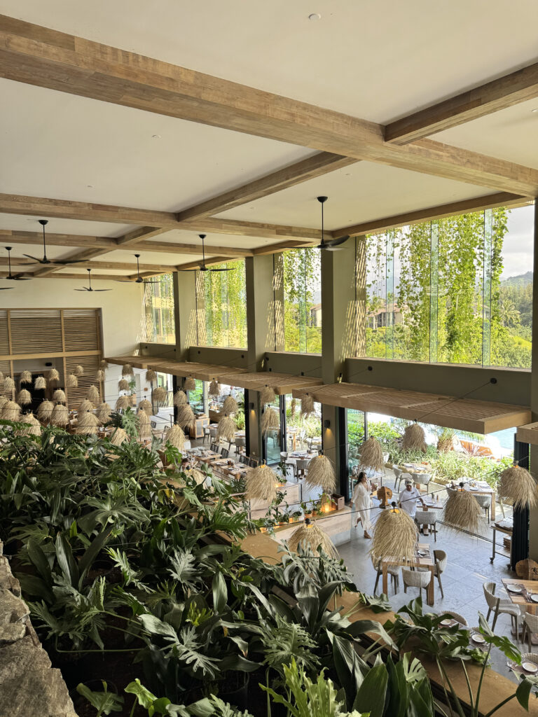 Open-air restaurant with hanging plants at 1 Hotel Hanalei Bay
